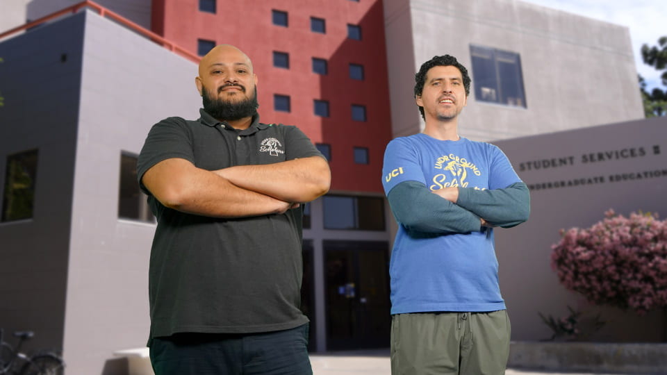 Hector Cervantes (Director of the UCI Underground Scholars Program) and Shawn Khalifa pose in front of UCI Student Services II